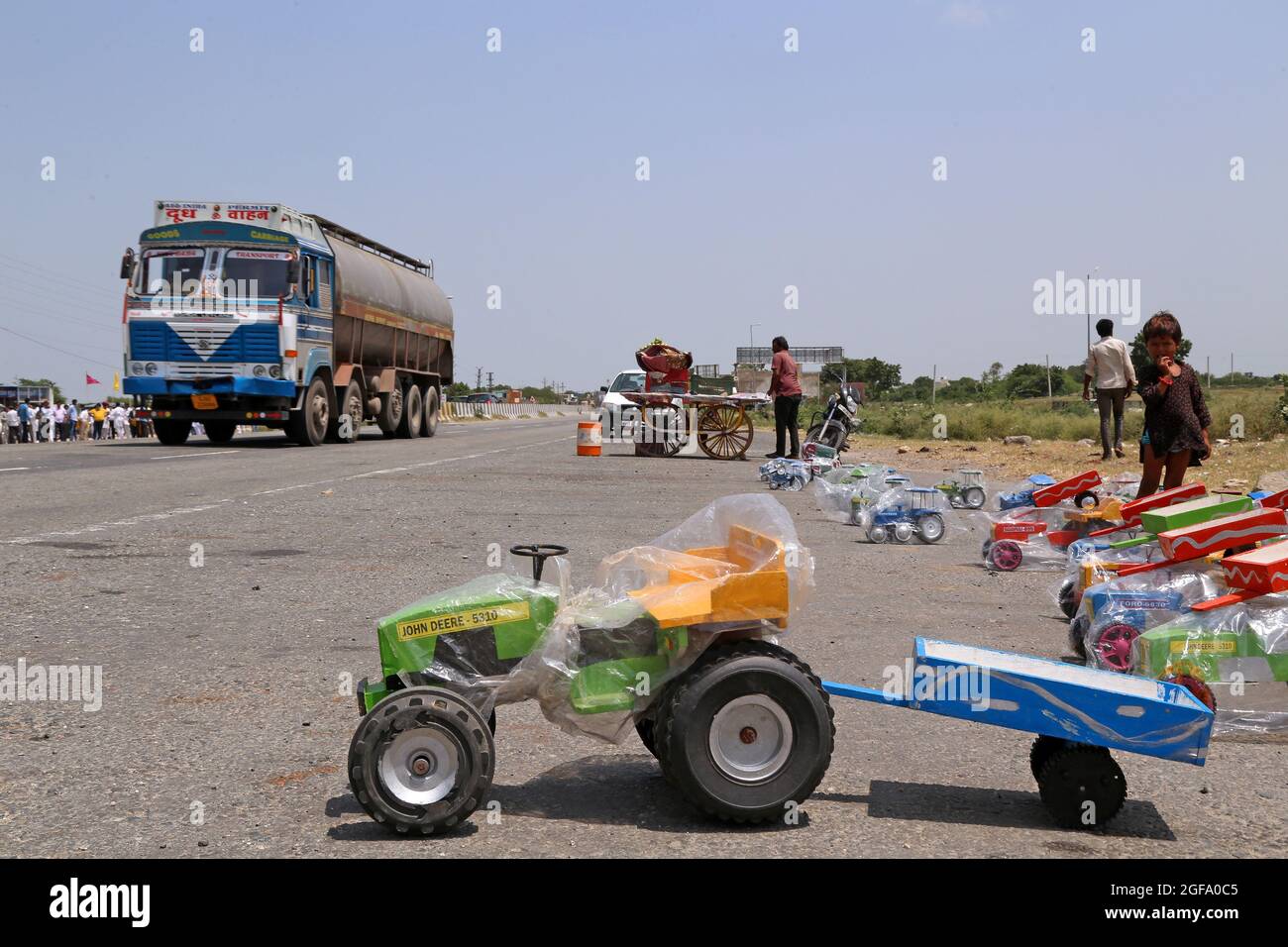 Beawar, India. 24 agosto 2021. Venditore di strada che vende giocattoli per veicoli, aspetta il cliente mentre i veicoli pesanti passano sulla Ahmedabad-Delhi National Highway a Beawar. (Foto di Eric Dubost/Pacific Press) Credit: Pacific Press Media Production Corp./Alamy Live News Foto Stock