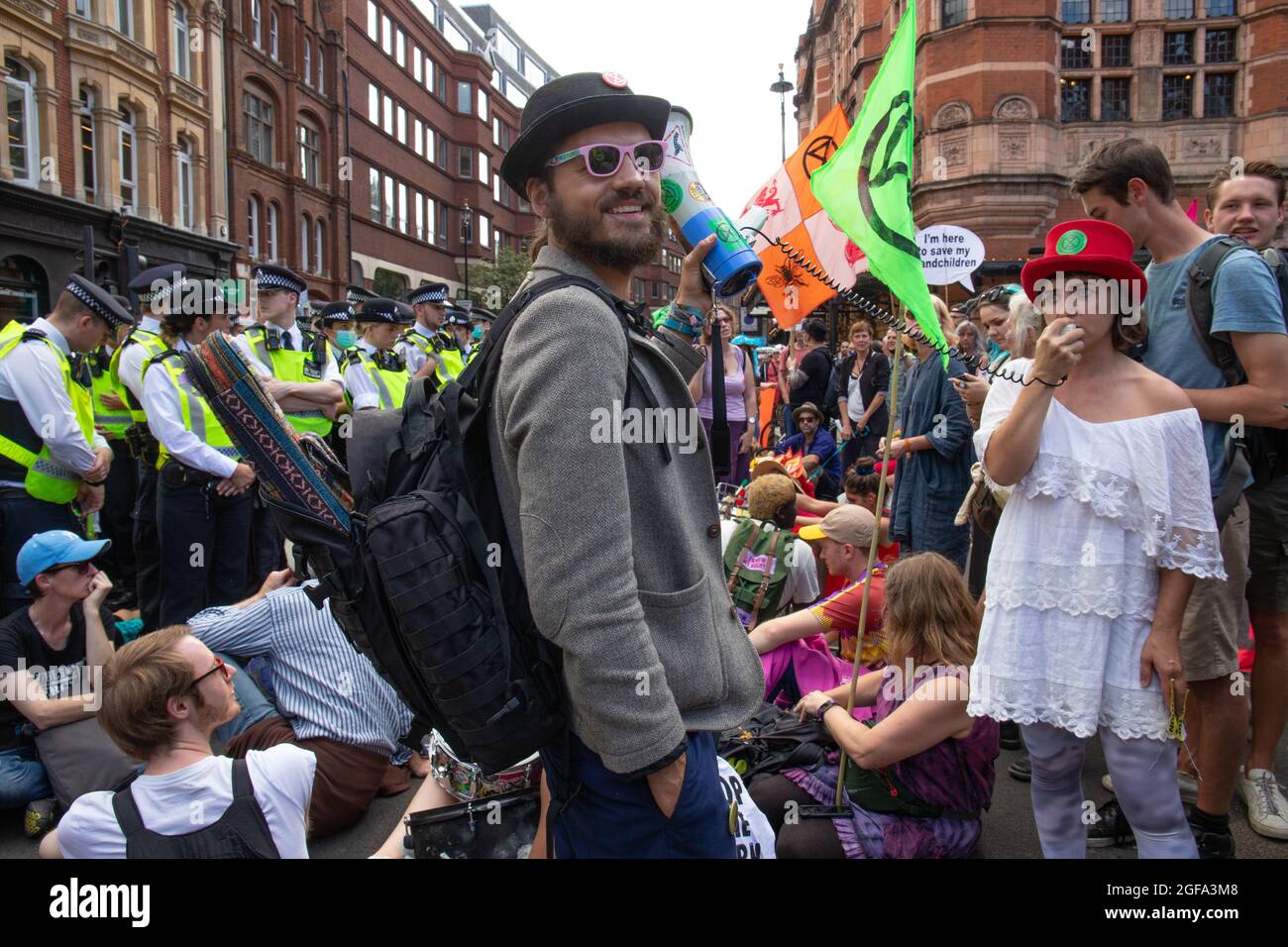 Londra, Inghilterra, Regno Unito 24 agosto 2021 giorno due della 'Inpossible Rebellion' e dei manifestanti di Extinction Rebellion Block Cambridge Circus. Usando un furgone con attivisti incolti e bloccati per bloccare la strada, un sistema audio e una protesta seduta giù. I manifestanti hanno ricevuto una pesante risposta da parte della polizia. Foto Stock