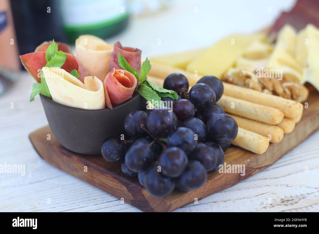 Salumi italiani con cracker di formaggio e salumi serviti su tavola di legno con bordo di corteccia grezzo Foto Stock