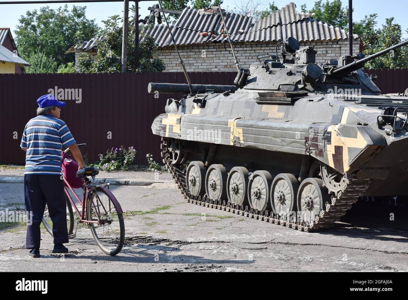 Marinka, Ucraina. 24 agosto 2021. Uomo anziano che guarda il veicolo di combattimento della fanteria durante il giorno dell'Indipendenza. 24 agosto, L'Ucraina celebra il 30° anniversario della sua indipendenza in onore dell'adozione da parte della Verkhovna Rada del SSR ucraino nel 1991 dell'atto di indipendenza dell'Ucraina - un documento politico e legale che ha certificato il nuovo status dello Stato ucraino. Credit: SOPA Images Limited/Alamy Live News Foto Stock