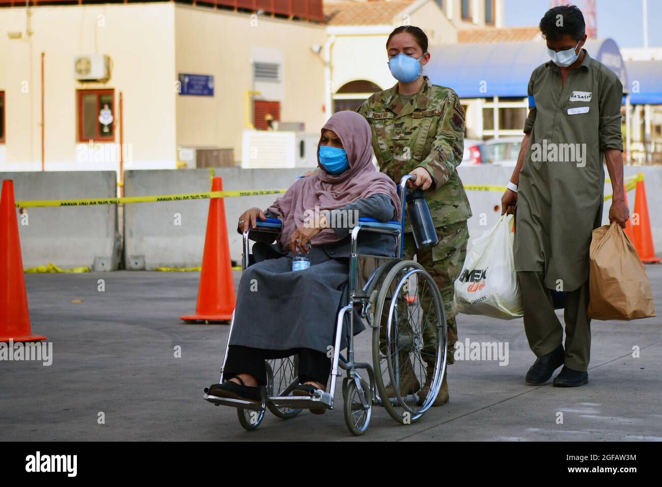 Senior Airman Romero assiste un evacuatore afghano a bordo della base aerea navale di Sigonella, 22 agosto 2021. NAS Sigonella sta attualmente sostenendo la missione del Dipartimento della Difesa per facilitare la partenza e il trasferimento in sicurezza dei cittadini statunitensi, dei beneficiari di visti speciali per l'immigrazione e delle popolazioni afghane vulnerabili provenienti dall'Afghanistan. Credito obbligatorio: Daniel Young/US Navy via CNP /MediaPunch Foto Stock