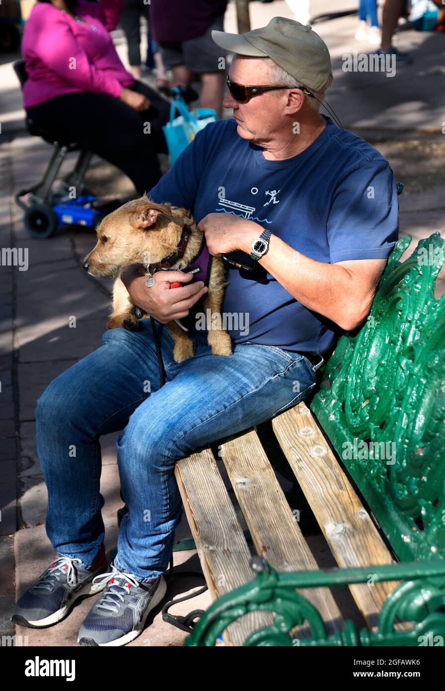 Un uomo si rilassa con il suo cane da compagnia su una panchina in un parco pubblico a Santa Fe, New Mexico. Foto Stock