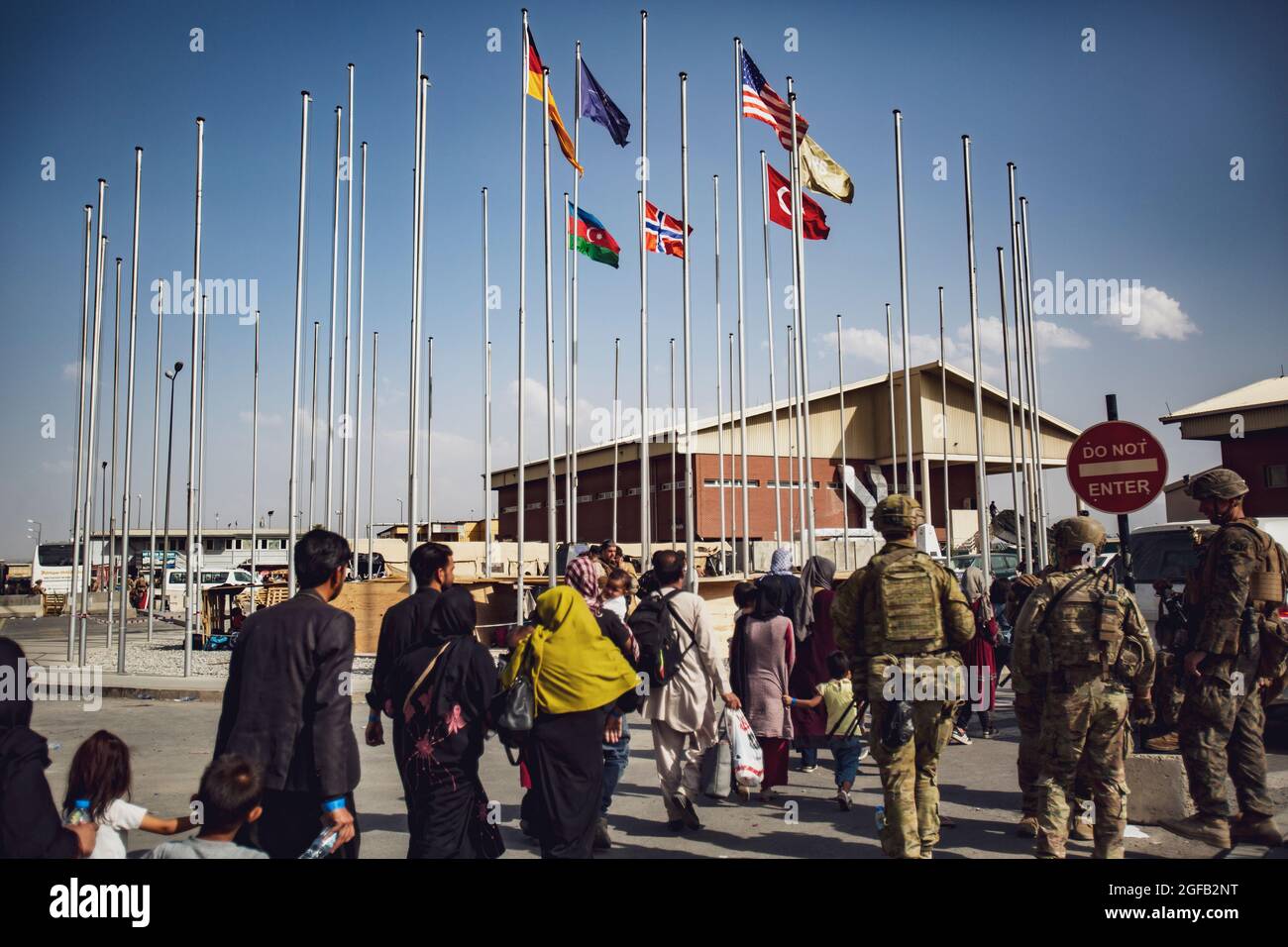I soldati assegnati alla 82° Divisione Airborne accompagnano un gruppo di persone al terminal dell'aeroporto internazionale Hamid Karzai, 23 agosto. I membri del servizio degli Stati Uniti stanno assistendo il Dipartimento di Stato con un'operazione DI evacuazione non combatante (NEO) in Afghanistan. (STATI UNITI Foto del corpo marino di 1° Ora. Mark Andries) Foto Stock
