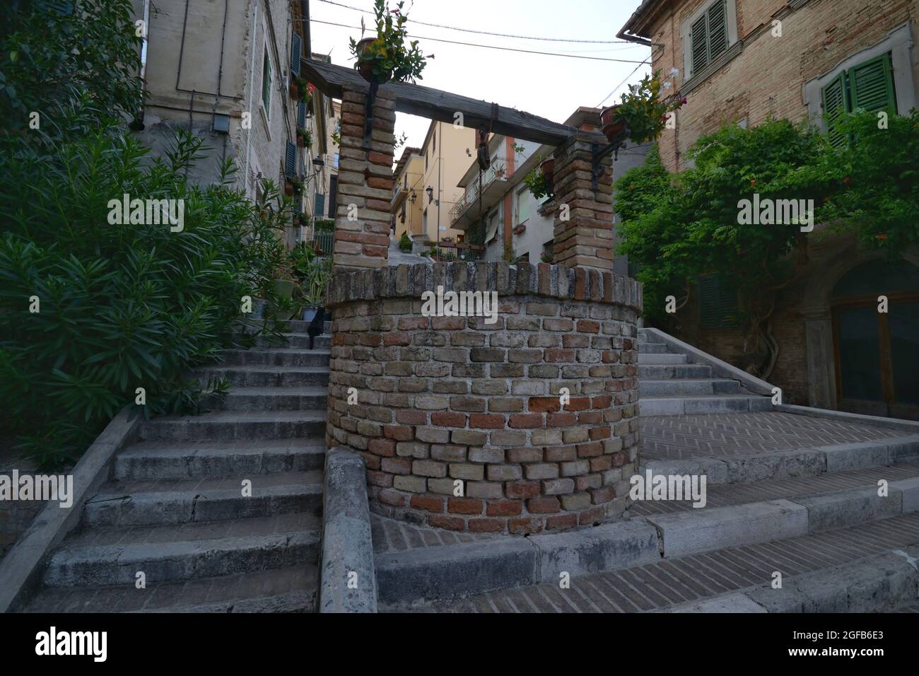 Pozzo d'acqua in mattoni medievali sulla scala della città di Corinaldo, Marche, Italia Foto Stock