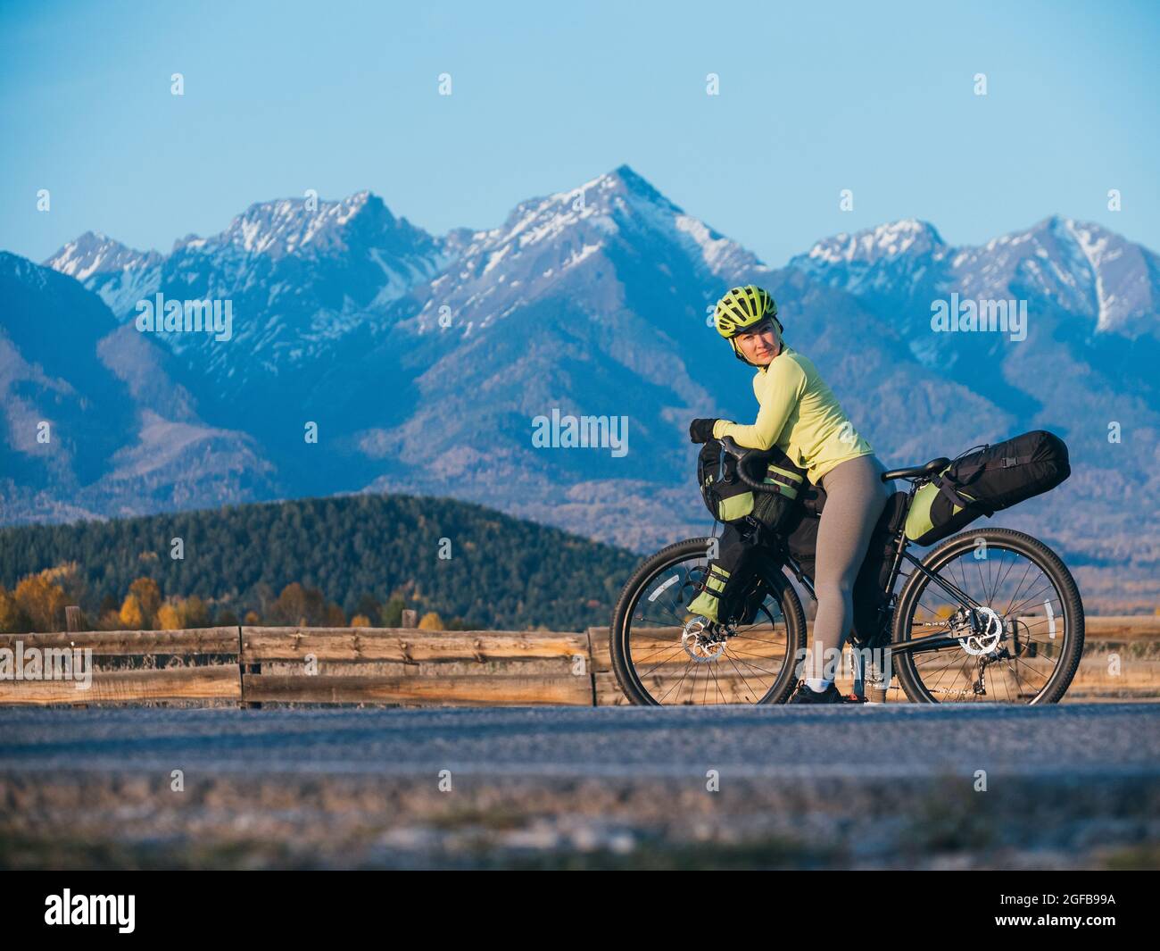 La donna viaggia in bicicletta su terreni misti con bikepacking. Il viaggio del viaggiatore con le borse della bicicletta. Sport turismo bikepacking. Foto Stock