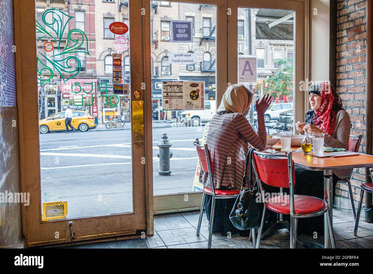 New York City, NY NYC, Manhattan Hell's Kitchen Pita Grill ristorante, interno interno femminile donne amici cliente musulmani indossare la testa sciarpa sc Foto Stock