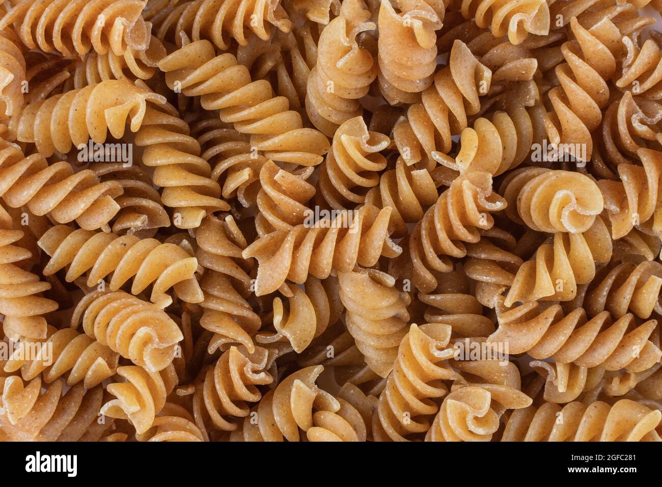 Fondo di pasta di fusilli di grano saraceno crudo senza glutine. Macaroni senza glutine integrali. Sfondo alimentare. Foto Stock