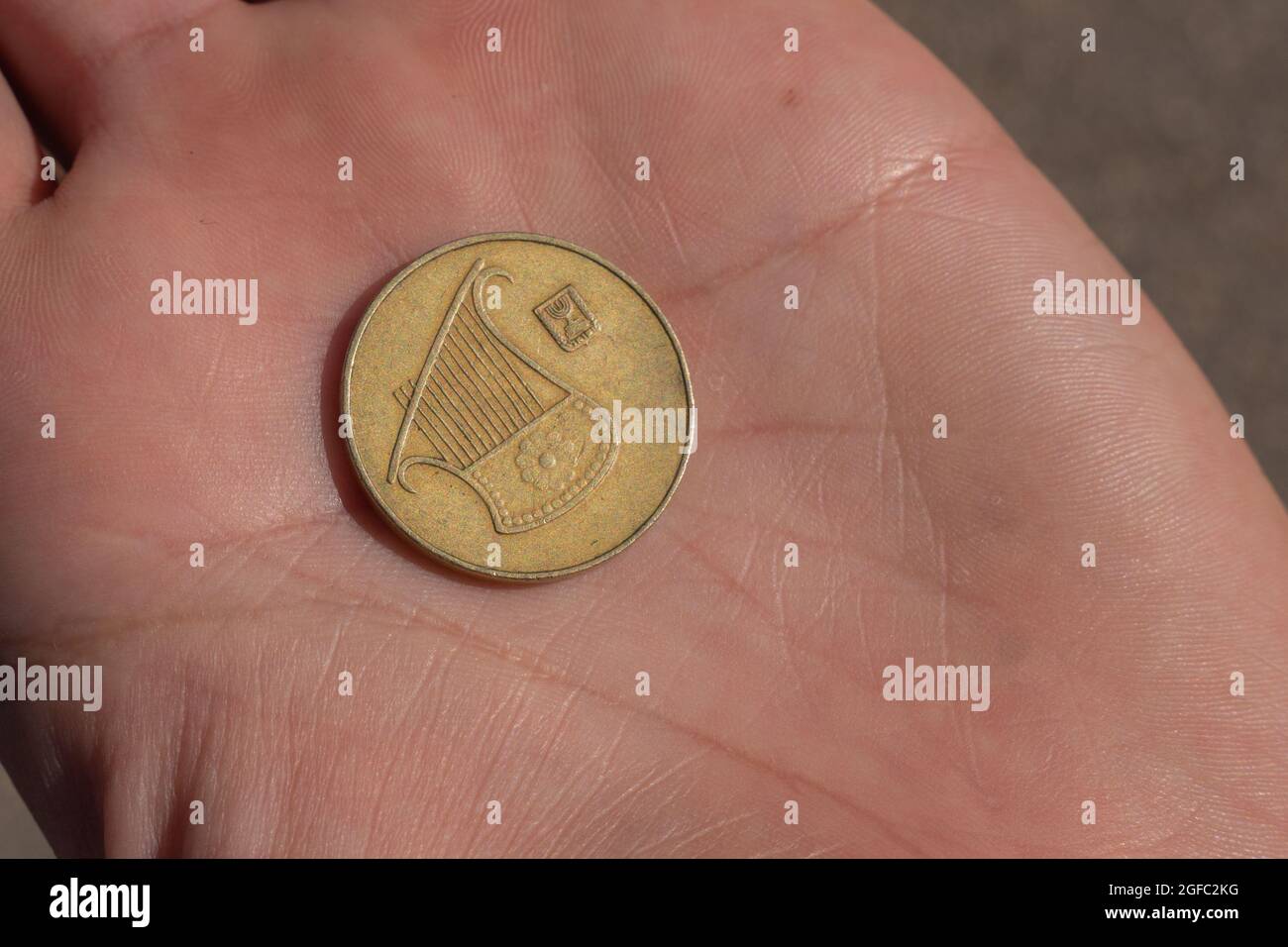 Moneta israeliana moderna in mano. 0,5 fogli Foto Stock