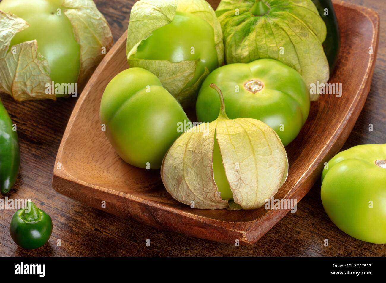Tomatillos, pomodori verdi, ingrediente della cucina messicana su sfondo rustico scuro in legno Foto Stock