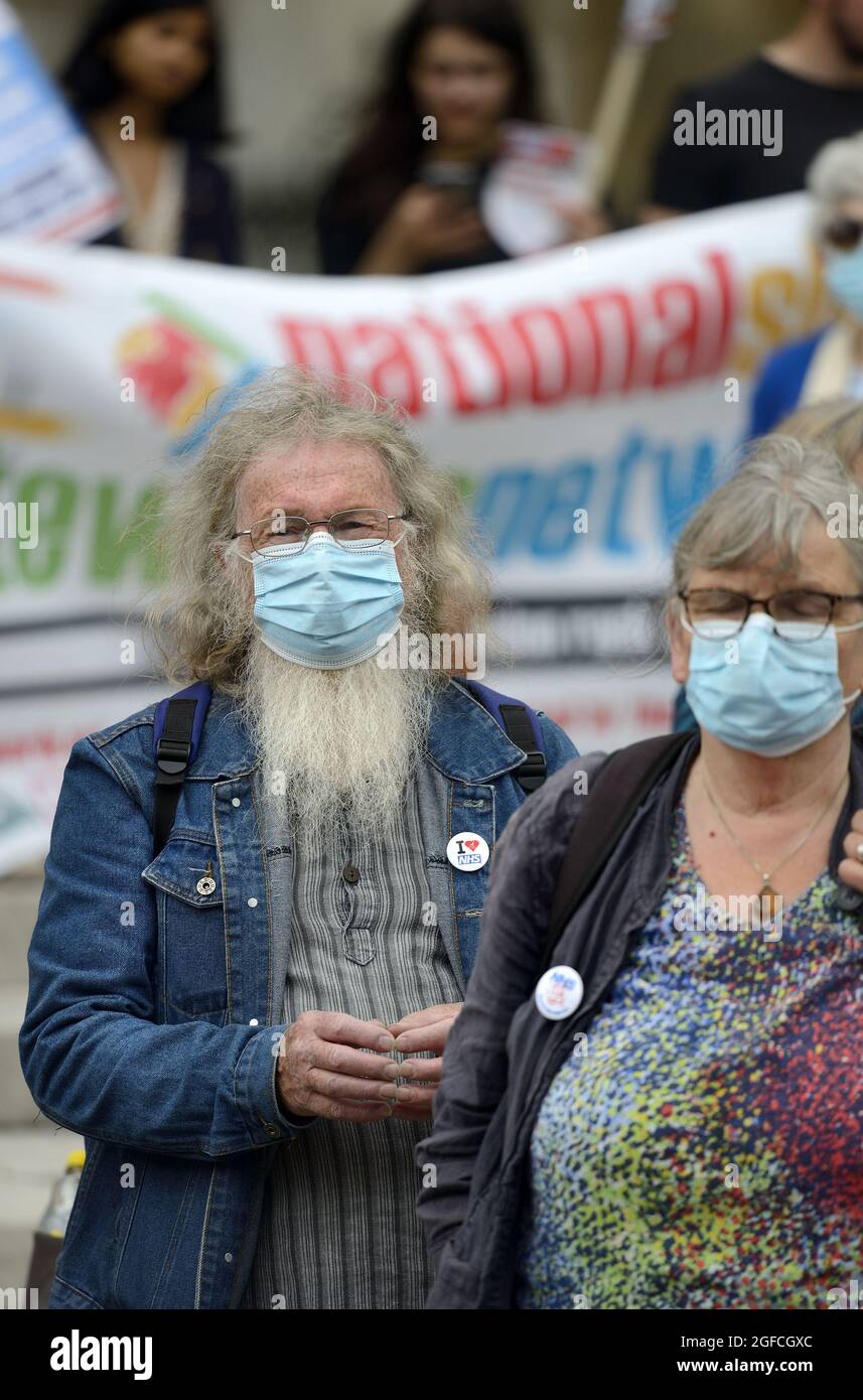 Londra, Inghilterra, Regno Unito. Persone a una dimostrazione professionale NHS durante COVID 2021 indossare maschere facciali, uno con una barba lunga e abbastanza capelli Foto Stock