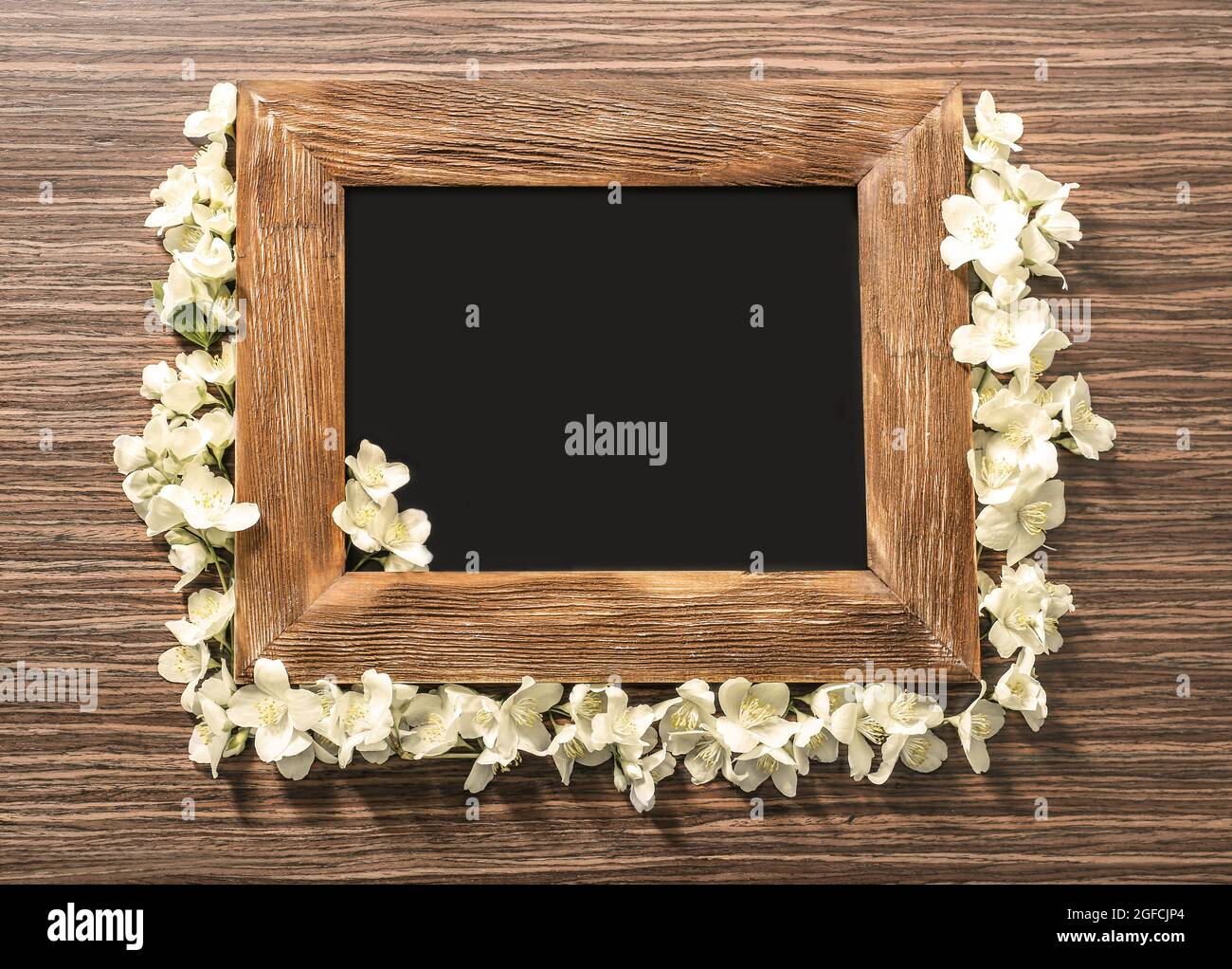 Cornice vuota e fiori di gelsomino fresco su sfondo di legno Foto stock -  Alamy