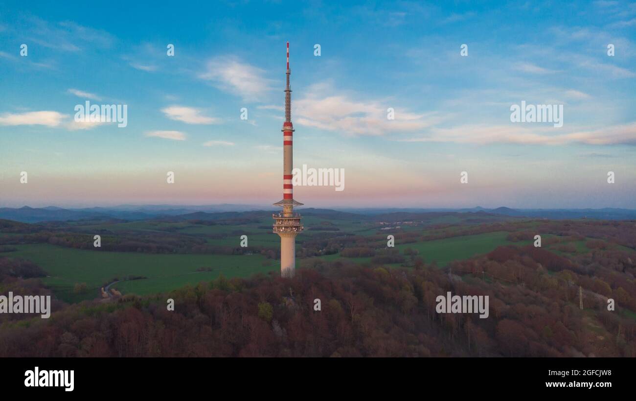 La torre della televisione di comunicazione su Bukova hora è la torre di trasmissione indipendente più alta della Repubblica Ceca. Vista aerea del paesaggio ceco al tramonto Foto Stock