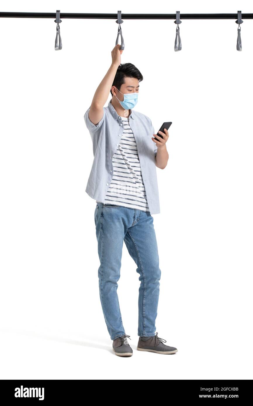 Giovane uomo d'affari con maschera chirurgica utilizzando smartphone in metropolitana Foto Stock