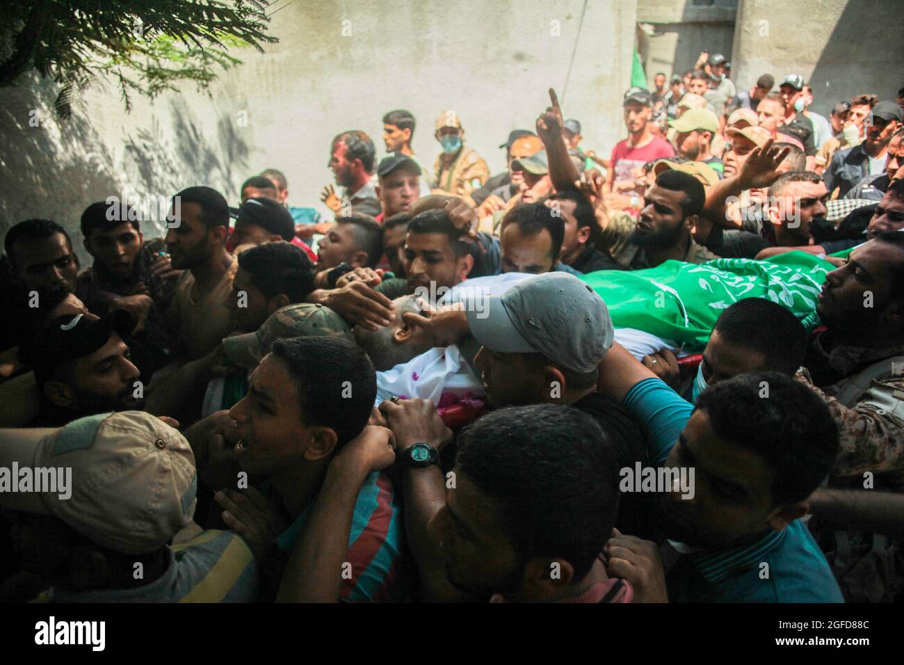 I lutto palestinesi trasportano il corpo di Osama Deeij, morto di una ferita che ha sostenuto durante una protesta anti-Israele contro la recinzione di confine Israele-Gaza la settimana scorsa, durante il suo funerale al campo profughi di Jabalia nella striscia settentrionale di Gaza il 25 agosto 2021. Foto di Ramez Habboub/ABACAPRESS.COM Foto Stock
