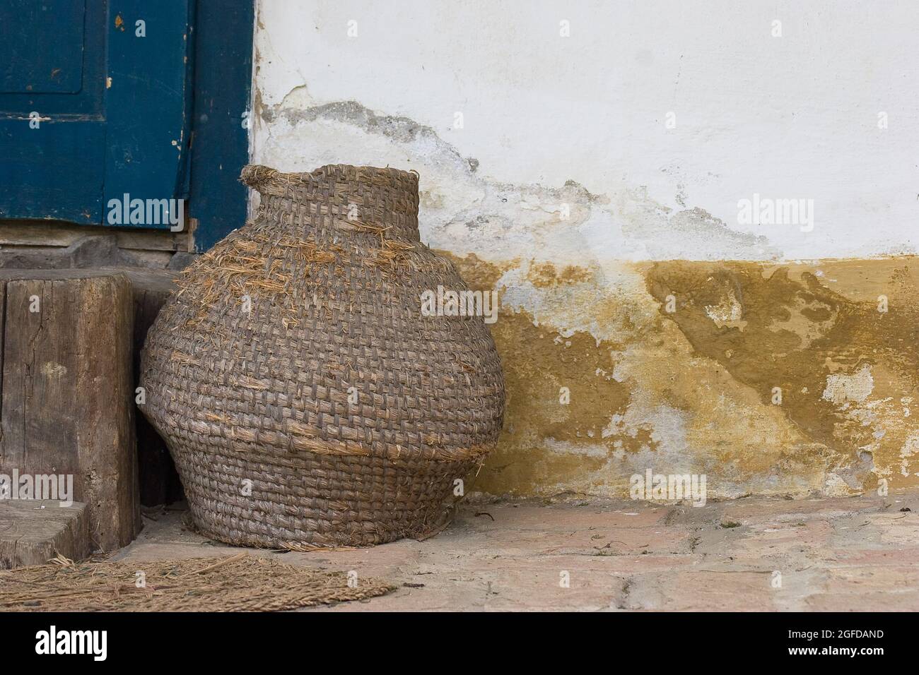 Cesto rotondo in vimini di fronte ad un casale. Foto Stock