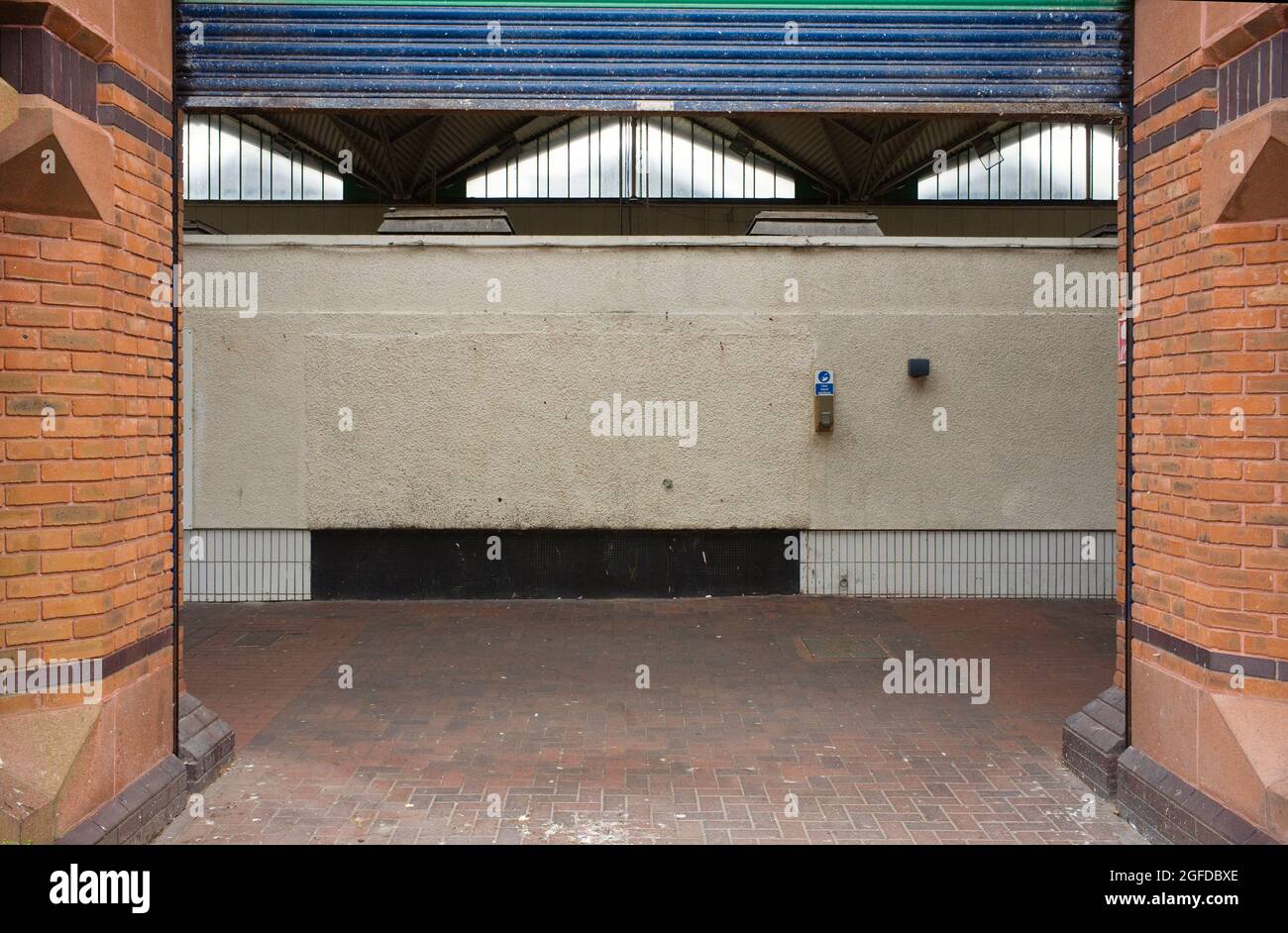 La fotografia più noiosa mai mostrando un muro vuoto e strada lastricata con sanitizer a mano sul muro al mercato Birkenhead Foto Stock