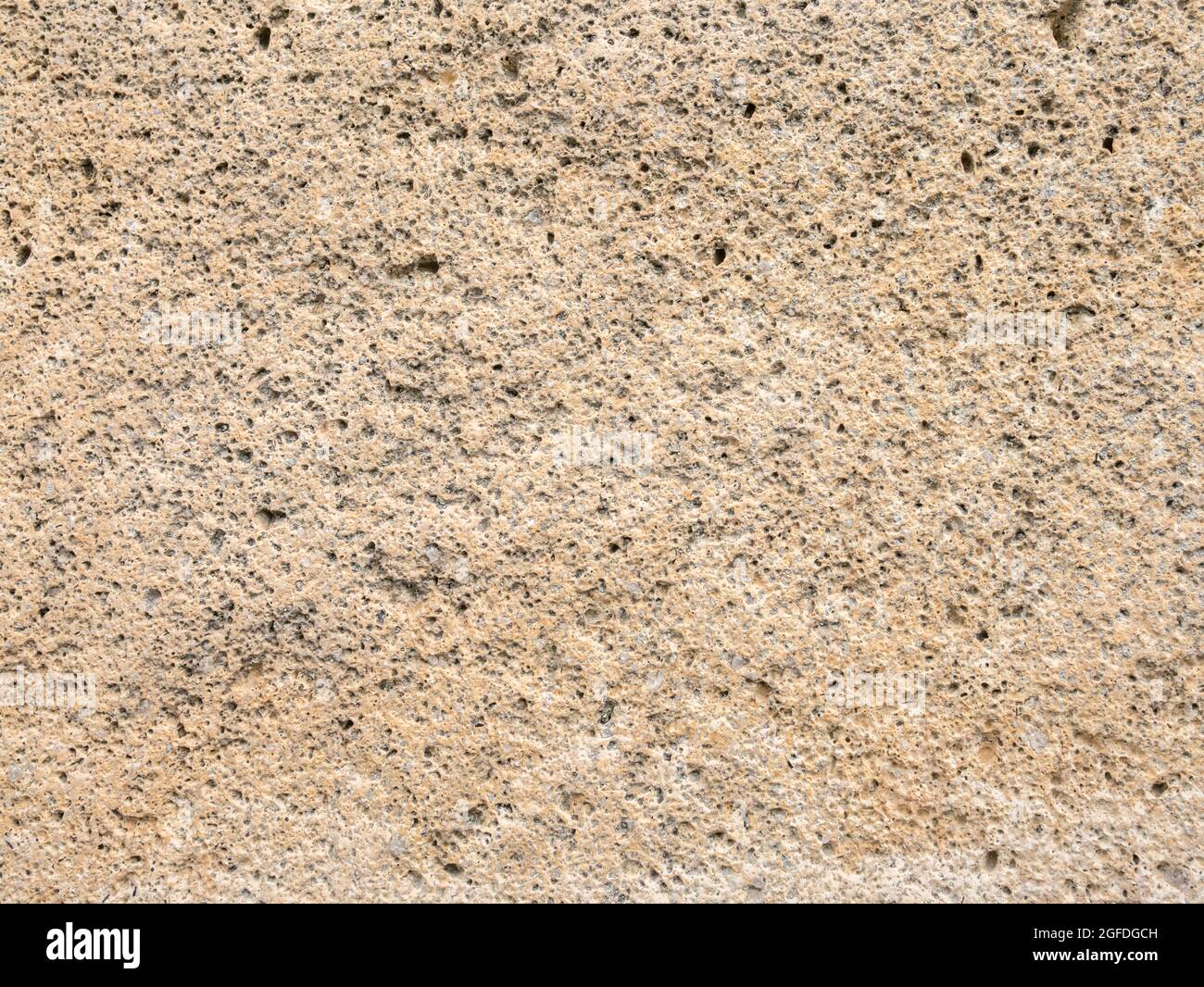 Primo piano di pietra arenaria gialla con intemperie che ha quasi una spugna o una spugna-come texture. Per lavori in muratura invecchiati, lavori in muratura decadenti. Foto Stock