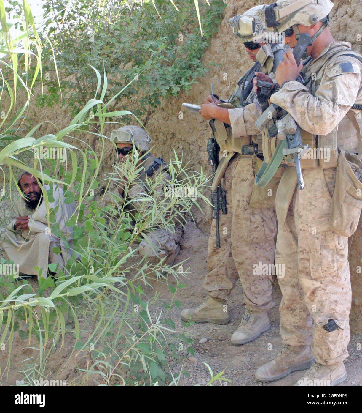 Marines with Golf Company, 2nd Battaglione, 9th Marine Regiment, raccogliere informazioni da un afghano locale durante un censimento operazione a Marjah, Afghanistan, 16 agosto. La squadra è stata attaccata a metà strada attraverso la pattuglia e ha coinvolto i talebani nemici nel processo. Foto Stock