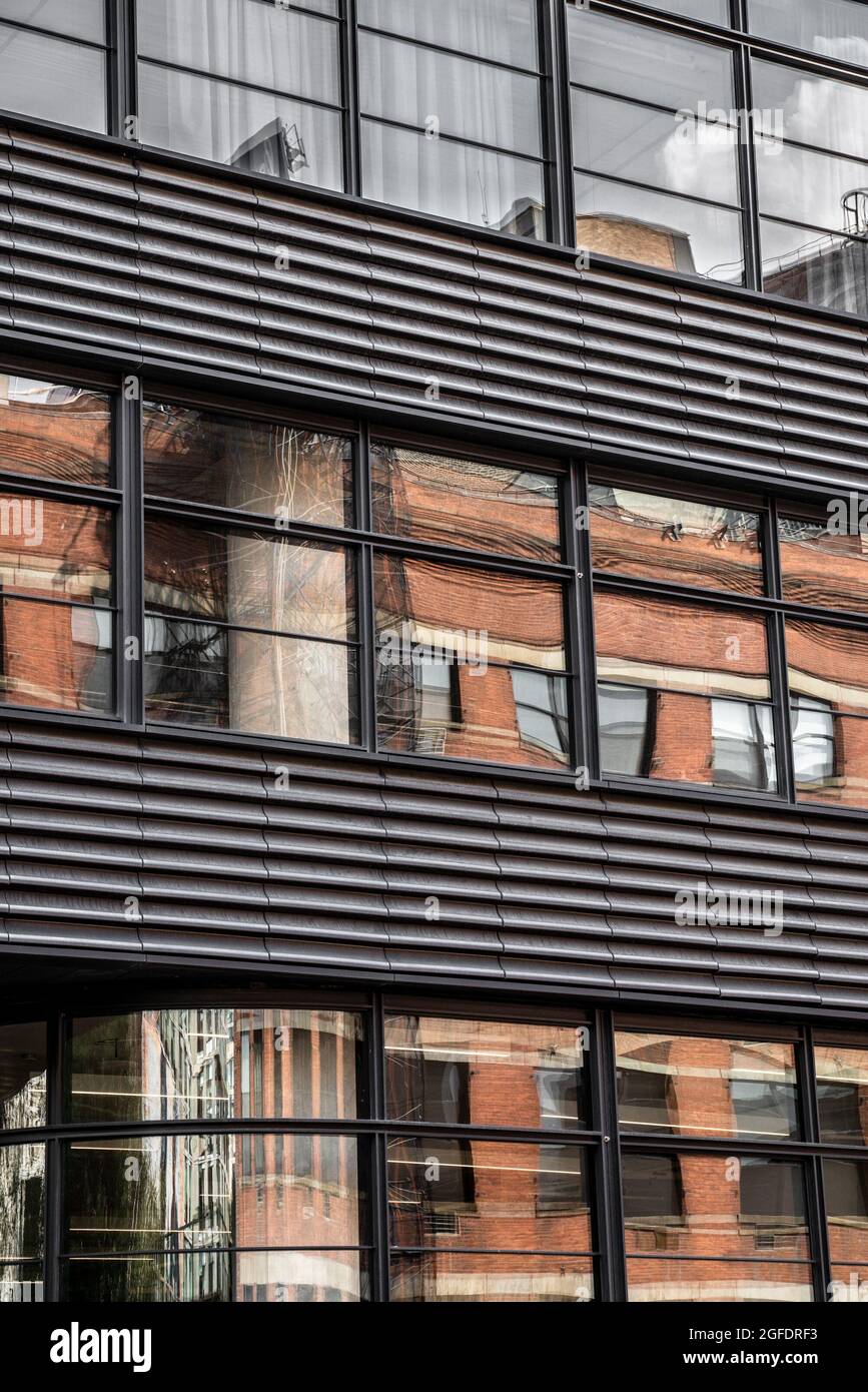 Moderno edificio urbano contemporaneo con metallo, finestre e riflessi. Foto Stock