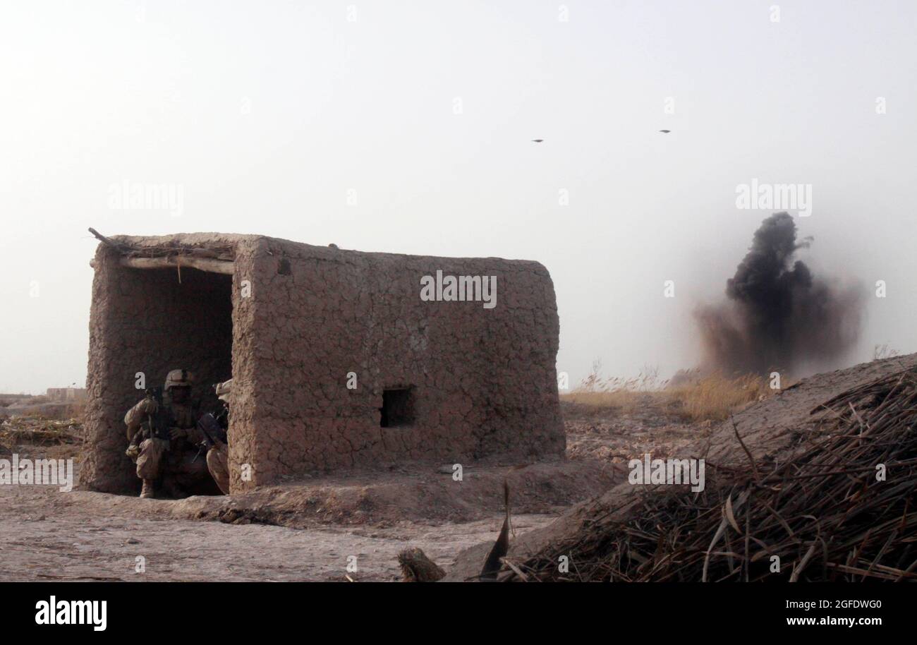 Primo Sgt. Fredrick A. Smith, primo sergente di Charlie Company, primo battaglione, terzo reggimento marino e Sgt. Harrison G. Rusk, capo sezione con la squadra combinata Anti-Armor 1, prende la copertura in un piccolo edificio di fattoria come una bomba da 500 libbre esplode su una posizione machinegun talebana e termina un fuoco Febbraio 14. I combattenti talebani iniziarono a pattugliare solo pochi minuti dopo il primo incontro tra Marines e gli anziani del villaggio dell'area dei cinque punti. Smith, 39 anni, è di Kingsland, GA., e Rusk, 23, è da Houston. Foto Stock