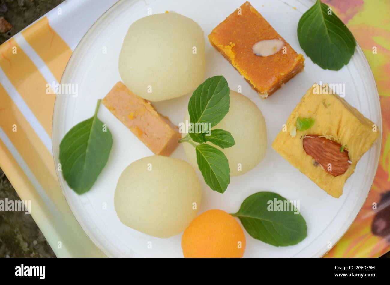 closeup il mazzo giallo grammo farina dolce, sciroppo riempito palla, marrone condensato latte dolce con menta verde su sfondo bianco marrone fuori fuoco. Foto Stock