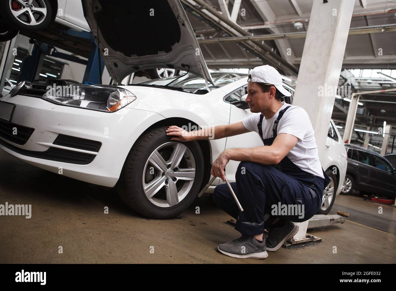 Tecnico di assistenza auto professionale che esamina le ruote di un auto Foto Stock