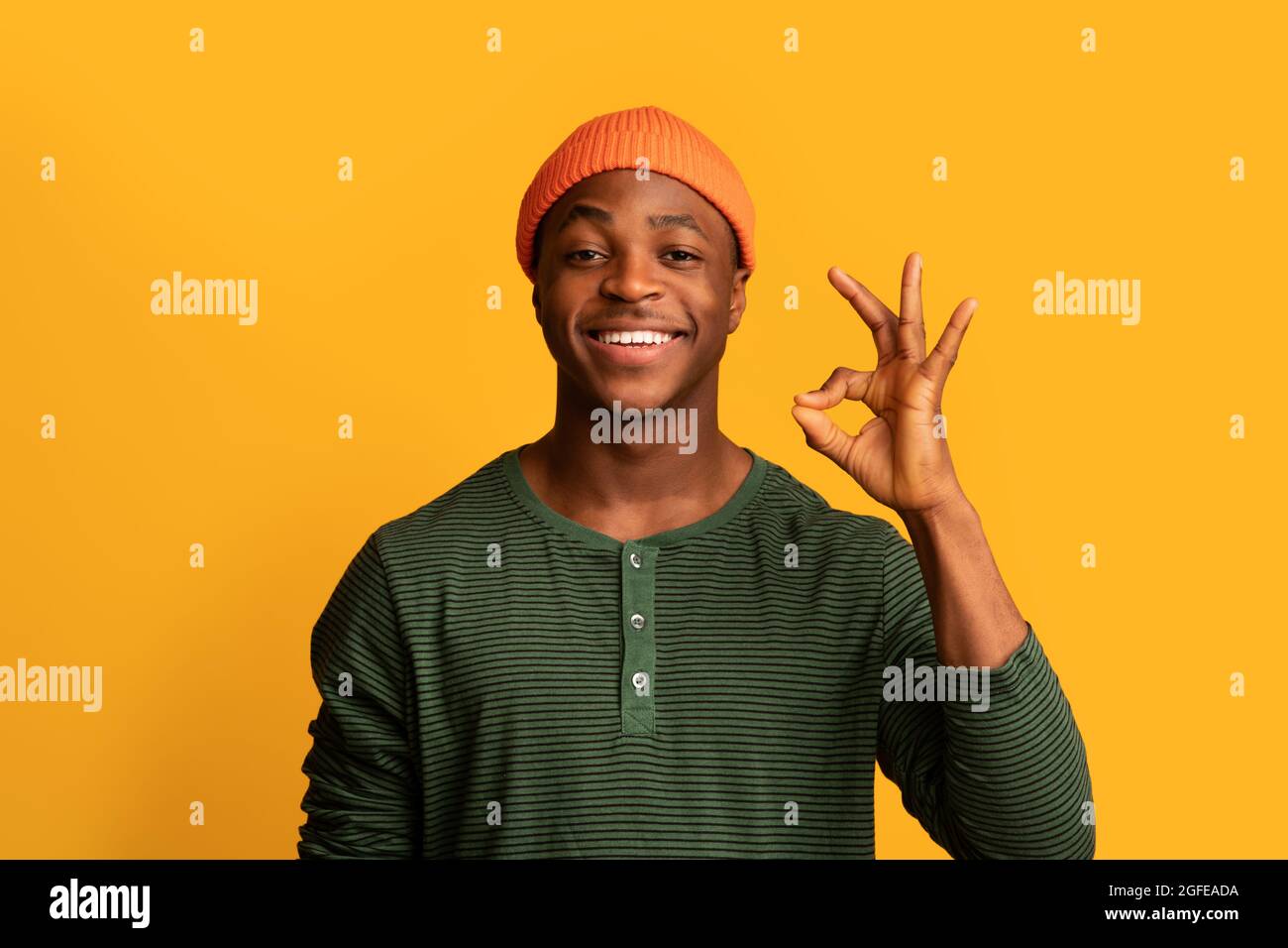 Ritratto del giovane ragazzo nero positivo che mostra il gesto OK alla fotocamera Foto Stock