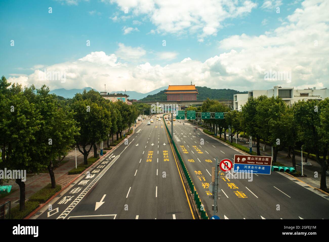 Auto in movimento su strada con tempio sullo sfondo, Taiwan Foto Stock