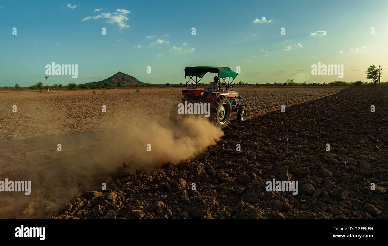 Coltivatore non identificato con trattore che prepara terra per seminare con coltivatore in mandsur, india. Foto Stock