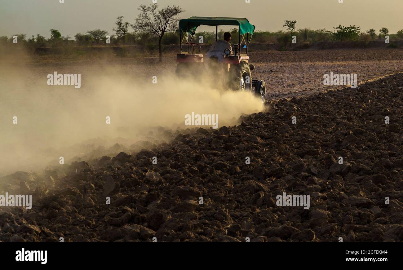 Coltivatore non identificato con trattore che prepara terra per seminare con coltivatore in mandsur, india. Foto Stock