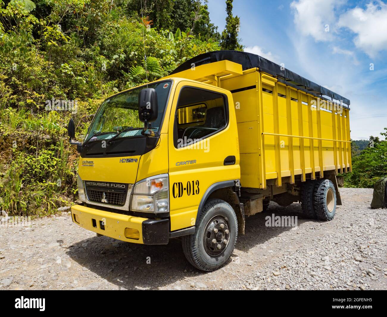 Bird's Head Peninsula, West Papua, Indonesia, Asia - Feb 2018: Grande camion giallo per il trasporto di merci e persone sulle strade ghiaiose degli Indoni Foto Stock