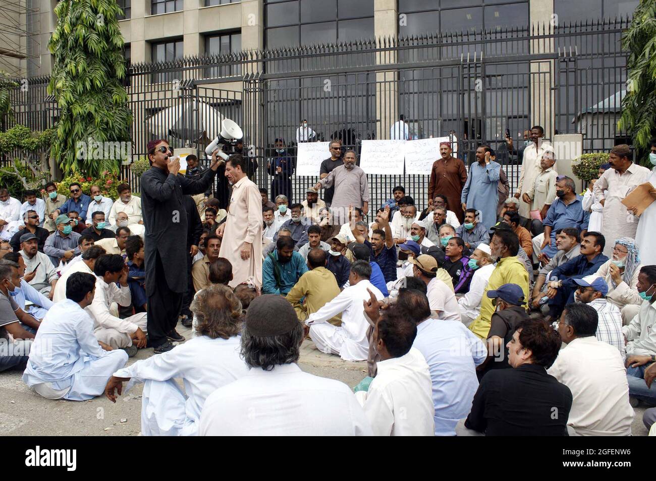 I dipendenti licenziati della sui Southern gas Company (SSGC) stanno tenendo una manifestazione di protesta contro l'amministrazione, al di fuori dell'ufficio SSGC a Karachi mercoledì 25 agosto 2021. Foto Stock