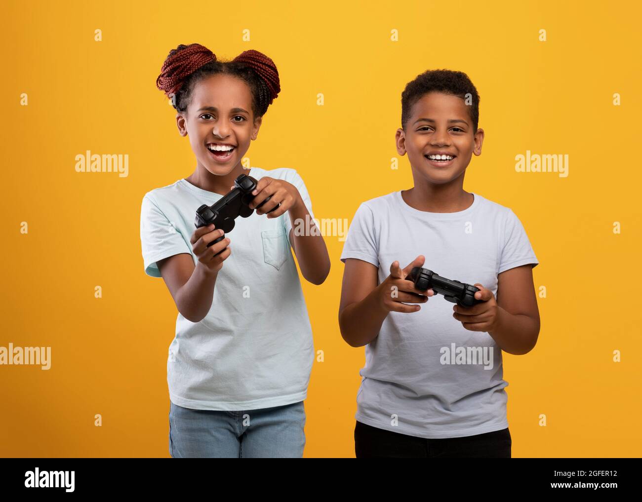 Emotivo fratello afroamericano e sorella con i joystick Foto Stock