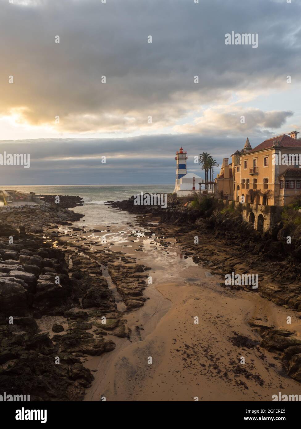 Sunrise vista di Santa Marta faro e il museo municipale di Cascais durante il deflusso dell'oceano, in Portogallo. Foto Stock