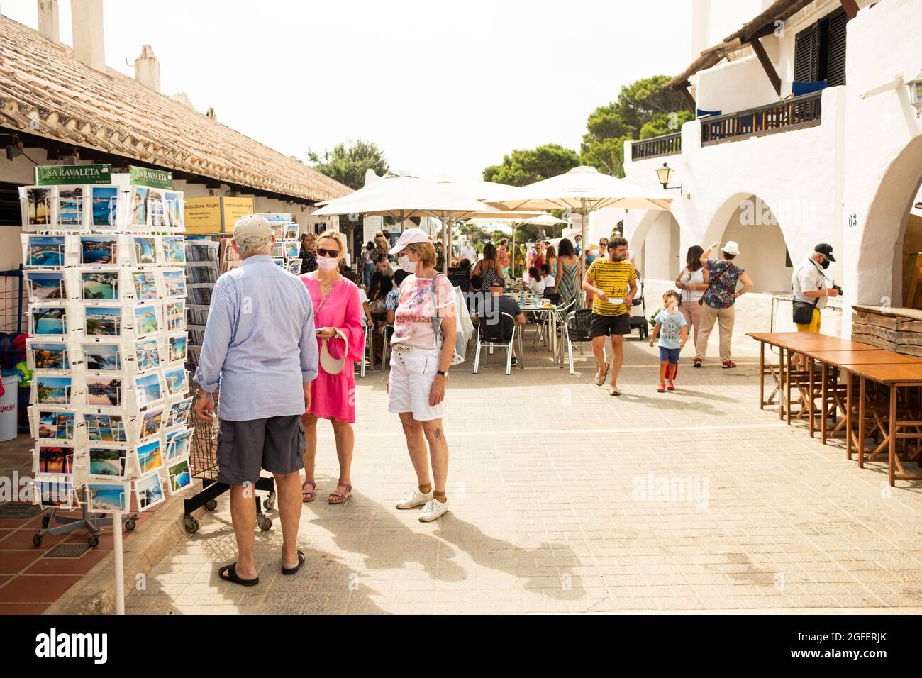 Fornelles, Spagna - 20 Agosto 2021: Turisti che indossano maschera visita turistica della città europea. Viaggi e turismo industria durante la corona virus PAN Foto Stock