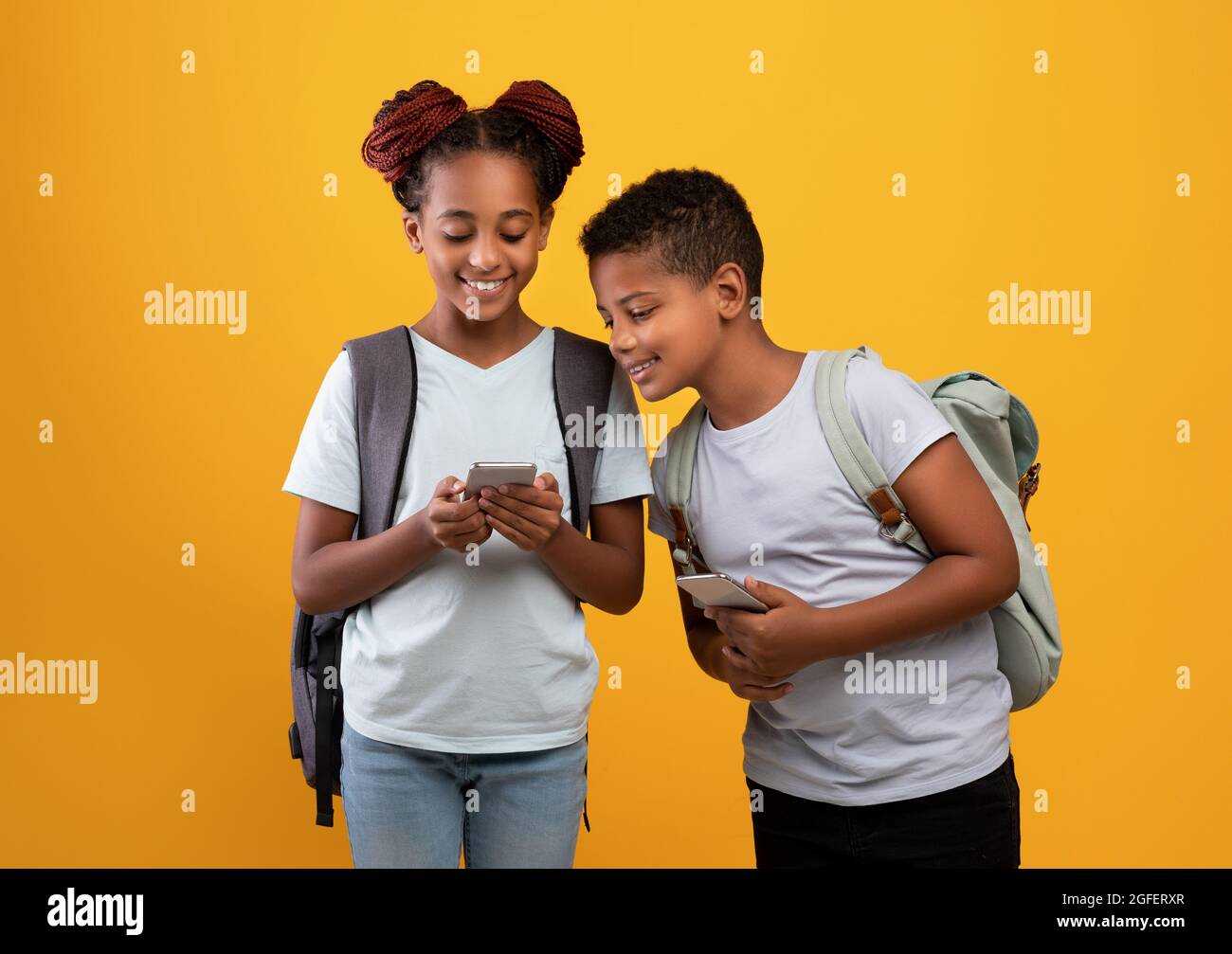 Ragazzi afro-americani e scolaresche con smartphone Foto Stock