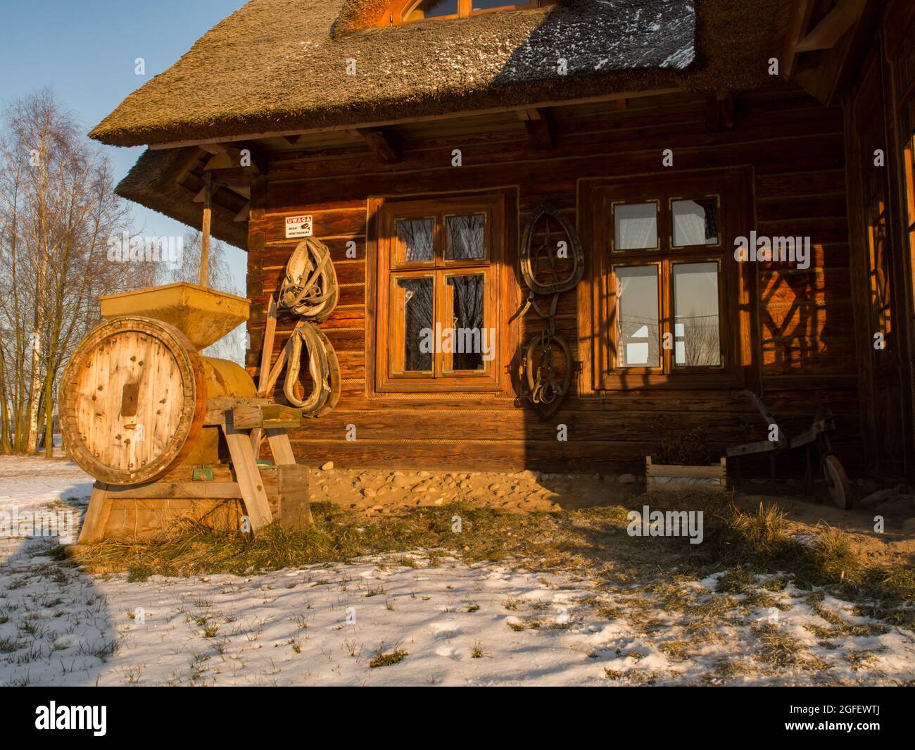 Polonia Gennaio - 2017: Bella casa di legno con tetto di paglia nei raggi del sole invernale. Edificio vecchio e originale che e' stato rinnovato. Europa orientale. Foto Stock