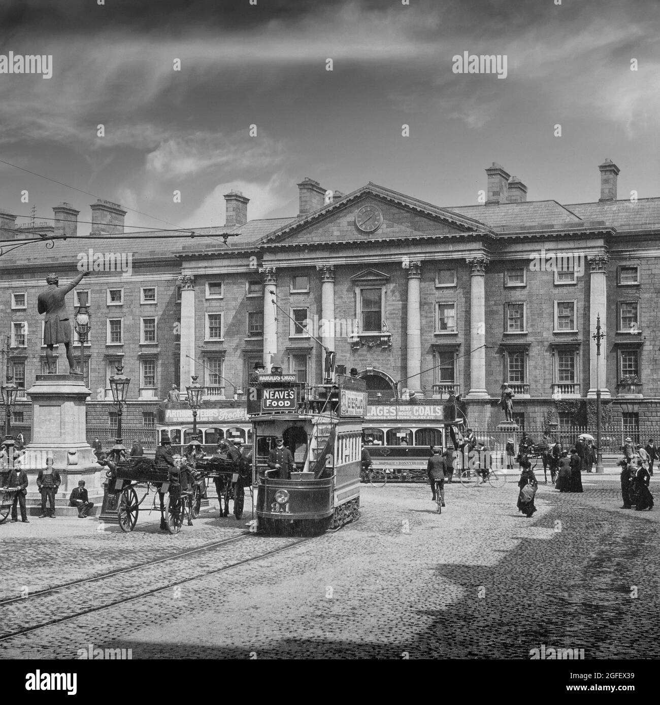 Una fotografia dei primi anni del XX secolo del Trinity College (Università) a College Green nel centro di Dublino, in Irlanda, con persone, veicoli trainati da cavalli e tram elettrici di nuova introduzione. Foto Stock