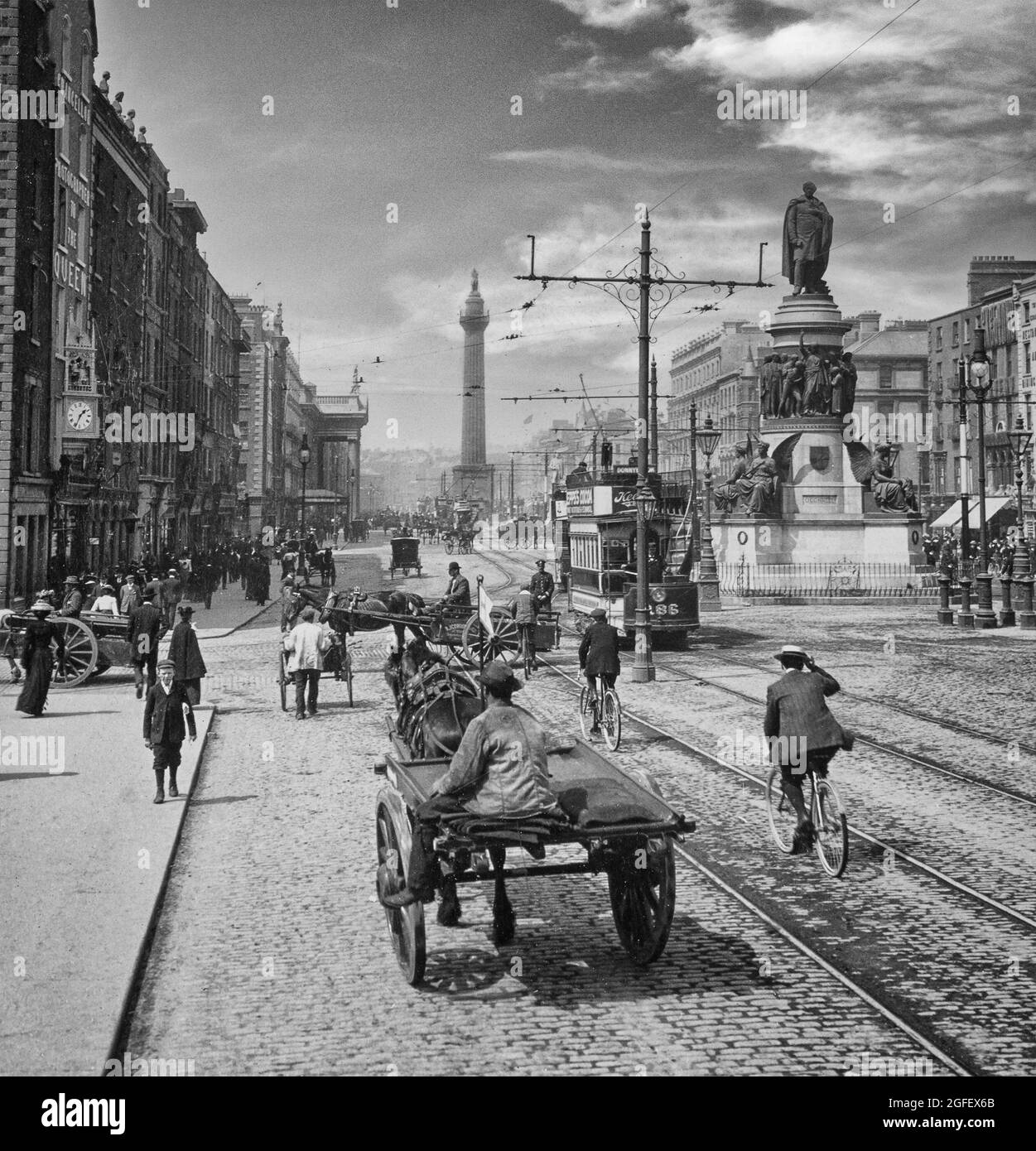 Una fotografia dei primi anni del XX secolo di veicoli trainati da cavalli a Sackville Street, in seguito rinominata o'Connell Street a Dublino, in Irlanda. La statua è quella di Daniel o'Connell e oltre è la colonna di Nelson e la facciata del General Post Office (a sinistra) Foto Stock