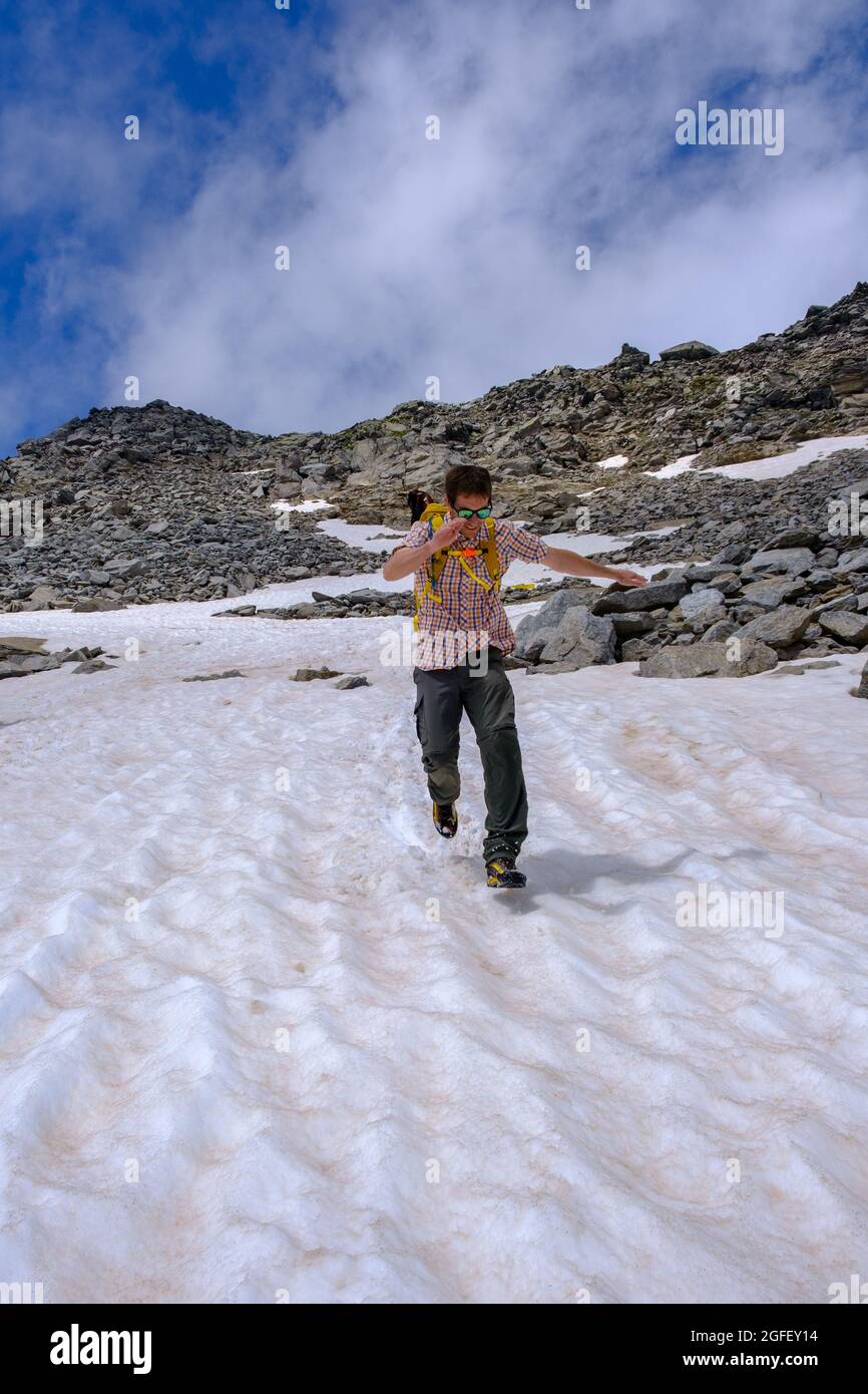 Uomo felice che corre e scivola sulla neve Foto Stock