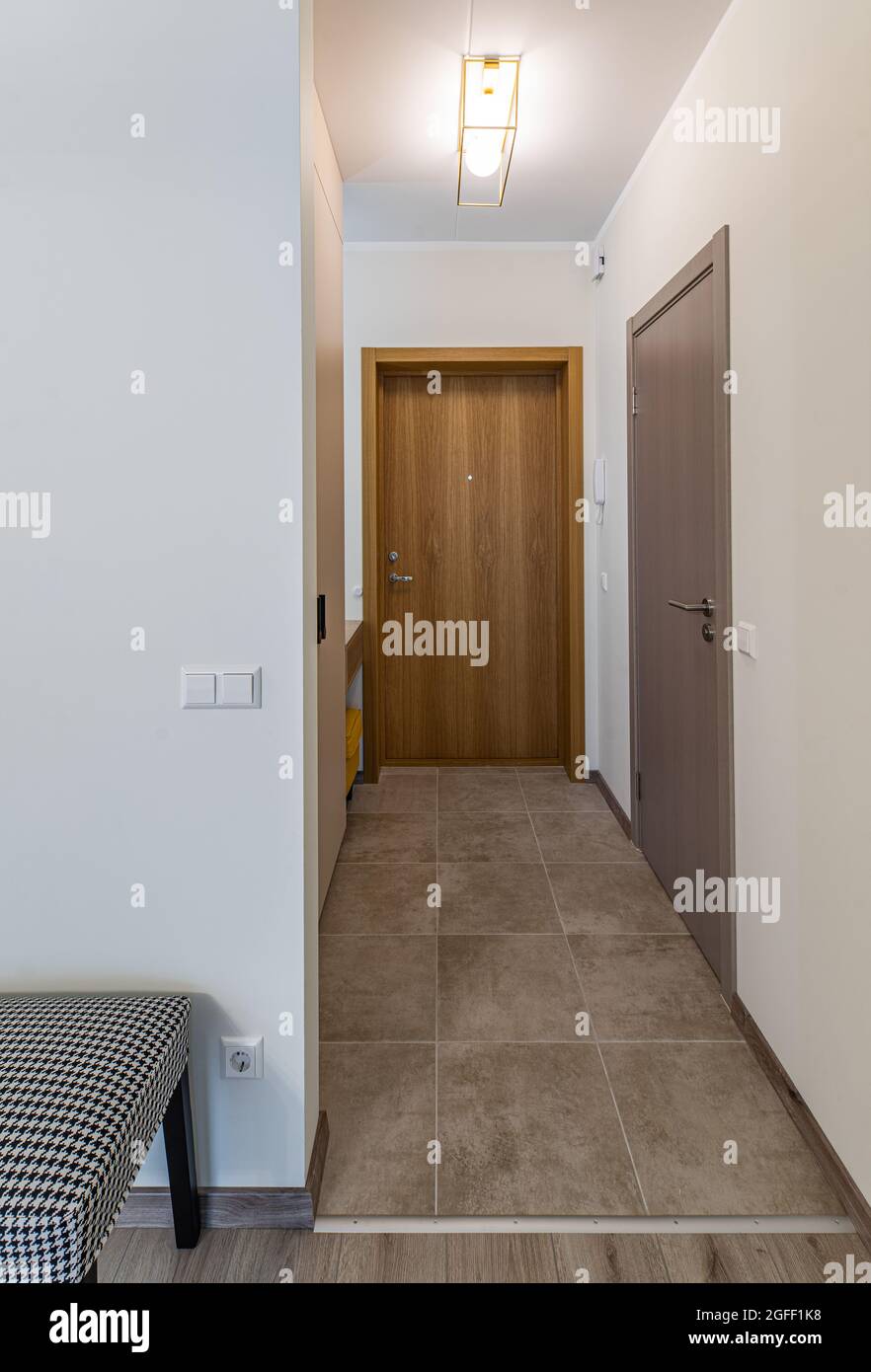 Interni moderni di appartamenti contemporanei. Pareti beige. Pavimento piastrellato. Ingresso. Foto Stock
