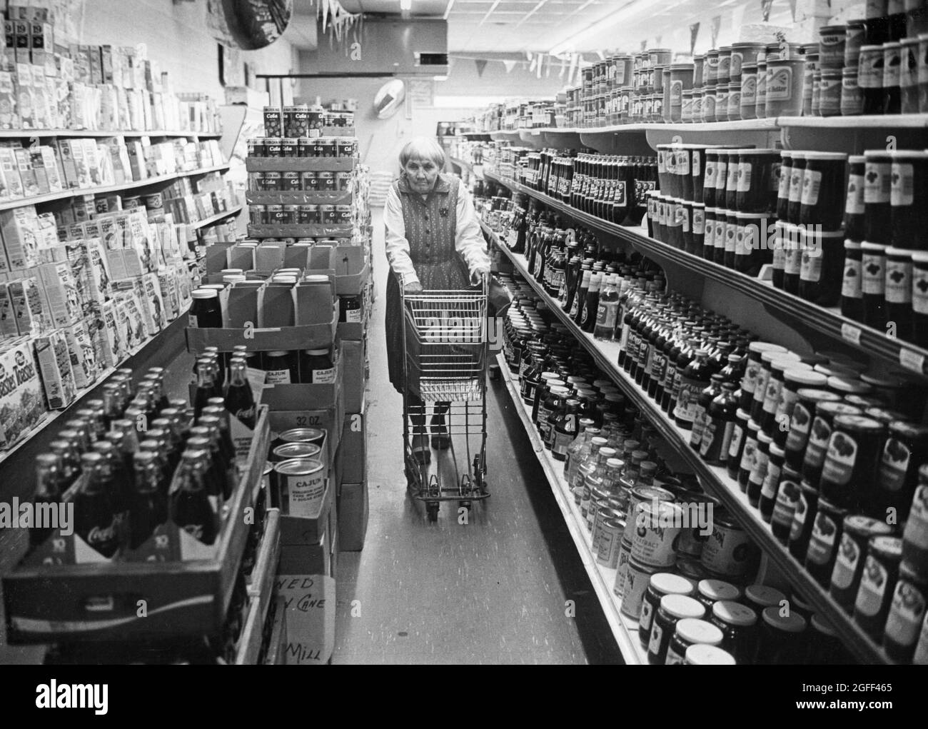 Calvert Texas USA, 1977: Foto sulla donna anziana, Elizabeth Meier di Calvert, Texas, vedova anni prima e vissuto in una casa di run-down in una piccola città del Texas. Qui lei spinge un carrello di alimentari mentre si fa shopping al piccolo negozio di alimentari locale. ©Bob Daemmrich Foto Stock