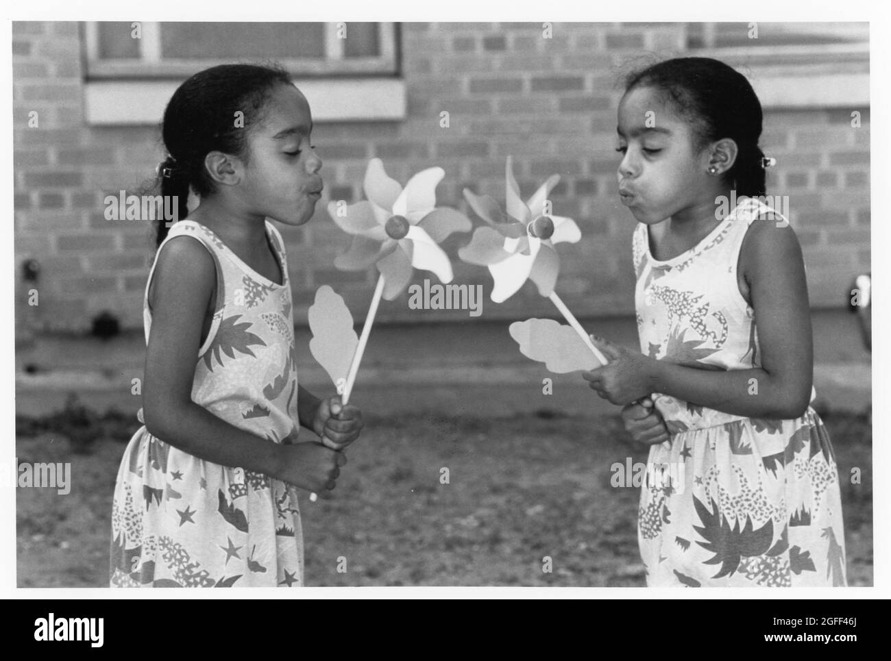 Austin Texas USA, circa 1993: Le sorelle gemelle nere di otto anni soffiano sui volani per farli girare .©Bob Daemmrich Foto Stock