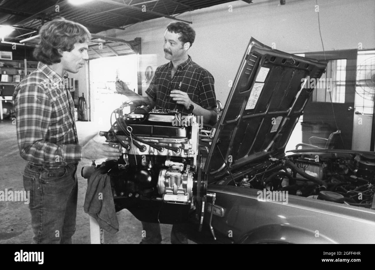 Austin Texas USA, circa 1991: Meccanici che lavorano su un'auto straniera in un negozio di riparazione automobilistica. ©Bob Daemmrich Foto Stock