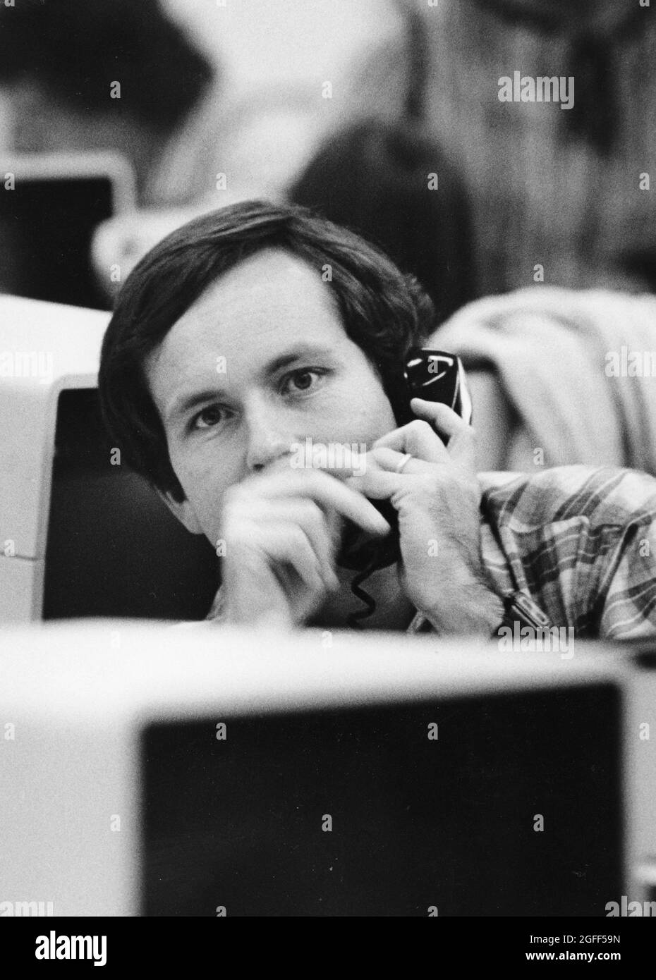 Austin Texas USA, circa 1984: Interviste reporter di notizie maschili oggetto per telefono alla sua scrivania in mezzo terminali di computer nella sala stampa del quotidiano, Austin American-statesman. ©Bob Daemmrich Foto Stock