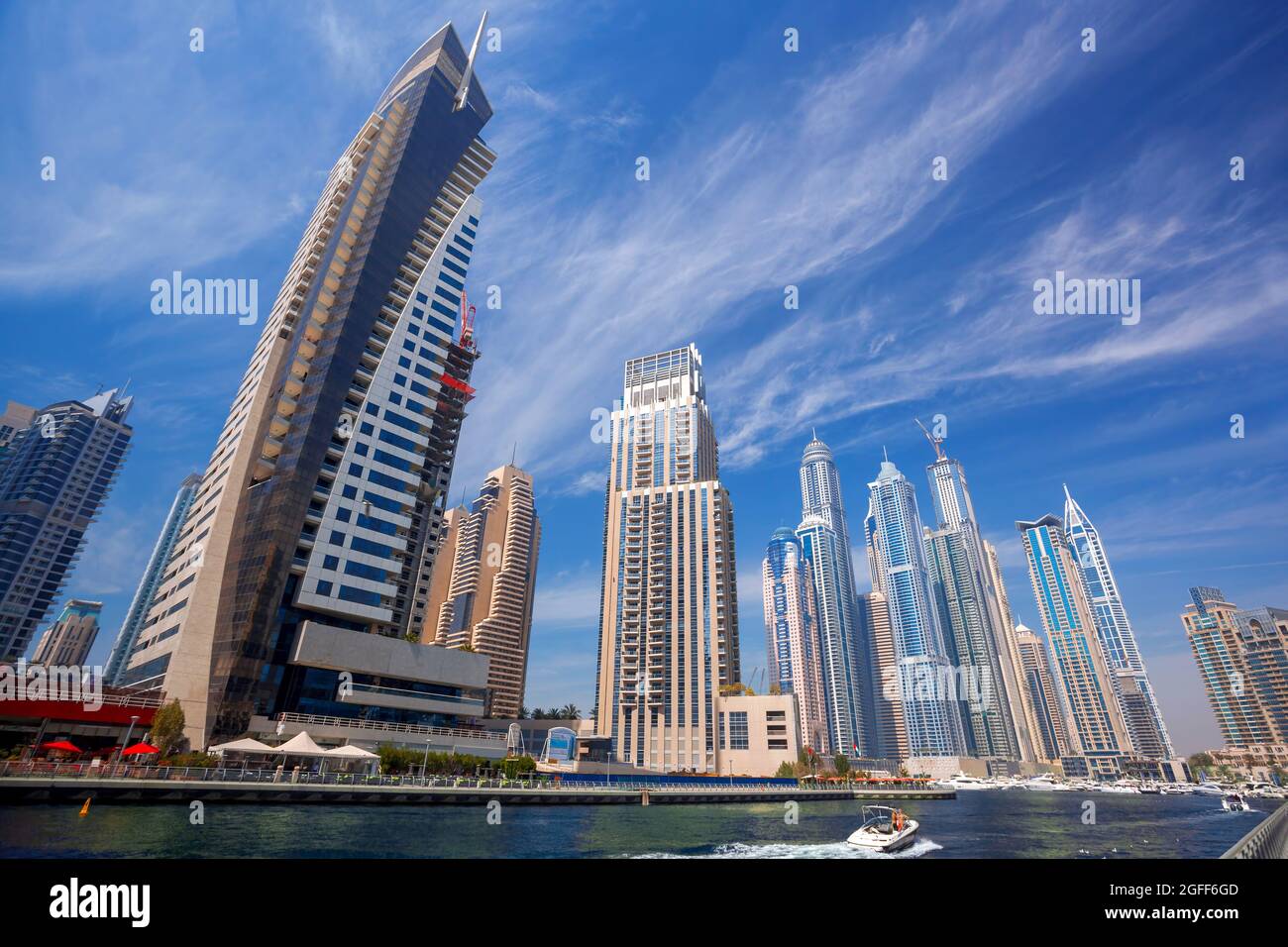 Dubai Marina con barche contro grattacieli di Dubai, Emirati Arabi Uniti Foto Stock