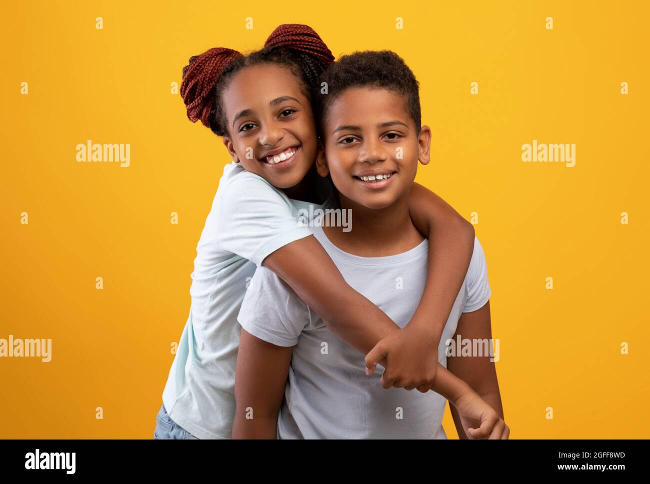 Carina ragazza teen nera abbraccia fratello, mostrando il suo affetto Foto Stock