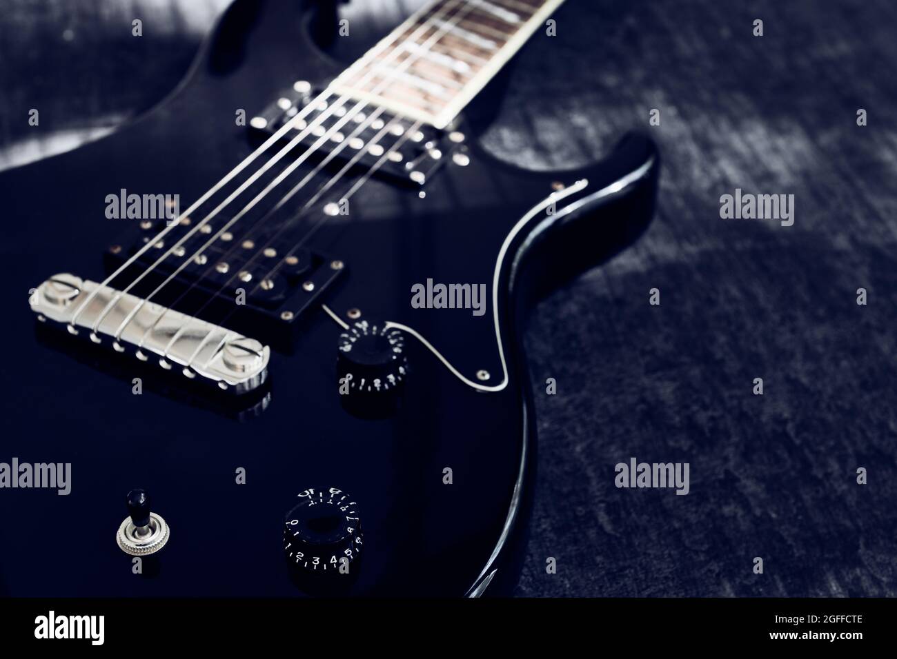 Vista macro della chitarra elettrica nera, messa a fuoco selettiva sull'impugnatura del regolatore di segnale, con spazio di copia, bassa profondità di nitidezza Foto Stock