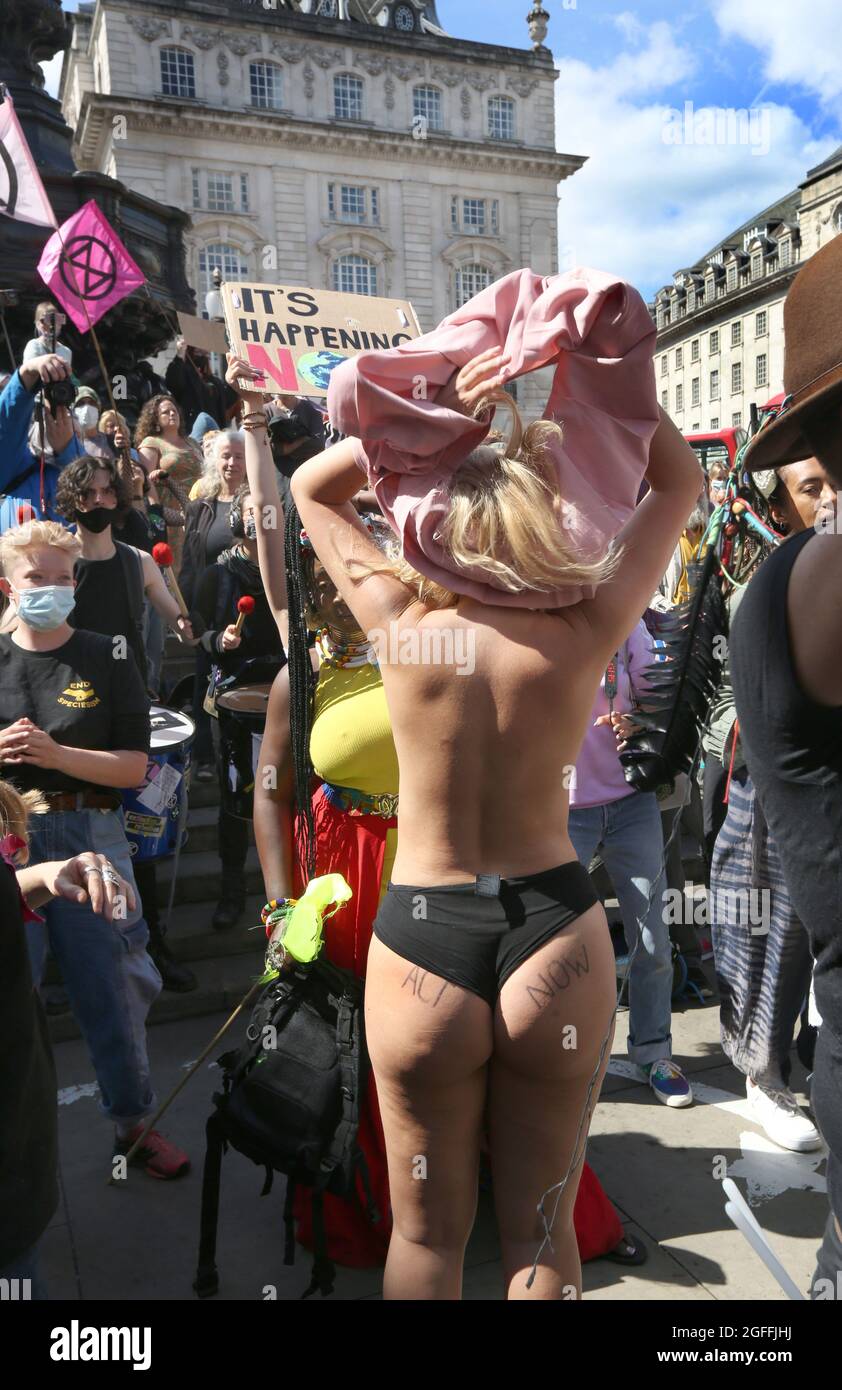 Londra, Regno Unito. 25 ago 2021. Un protester si spoglia per ballare alla samba band prima di marciare ad Oxford Circus, durante l'impossibile Rebellion - Day 3. Guidati da Female, intersex, non-binary e Trans (FINT) persone dalla ribellione di estinzione, i ribelli chiedono che il governo cambi le politiche per affrontare l'emergenza ecologica e climatica e fermare immediatamente tutti i nuovi investimenti di combustibili fossili. Credit: SOPA Images Limited/Alamy Live News Foto Stock