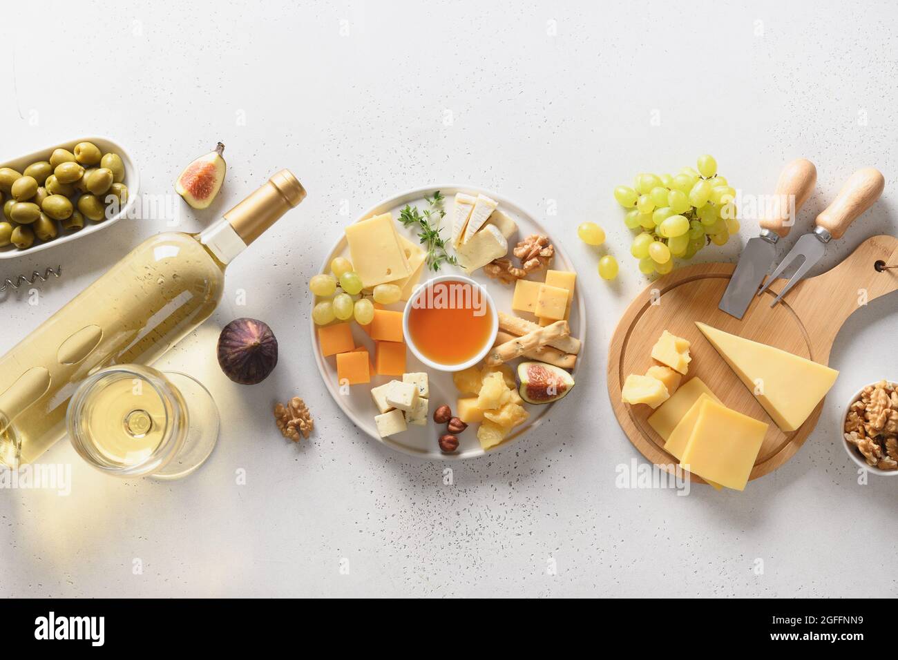 Piatto di formaggi con frutta e noci diverse su sfondo bianco. Banner. Vista dall'alto. Aperitivo gourmet per feste. Foto Stock